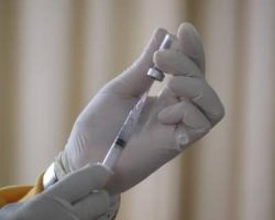 Image of gloved hand preparing a vaccination.