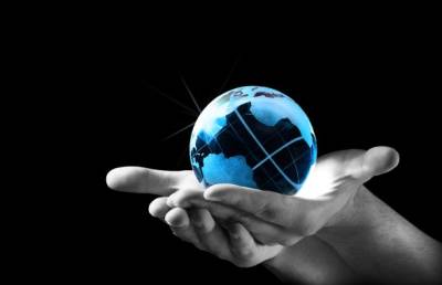 Glass globe representing the Earth cradled in two outstretched hands.
