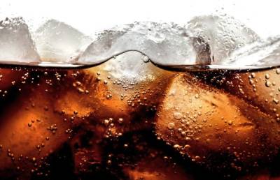Close-up image of ice cubes floating in soda.