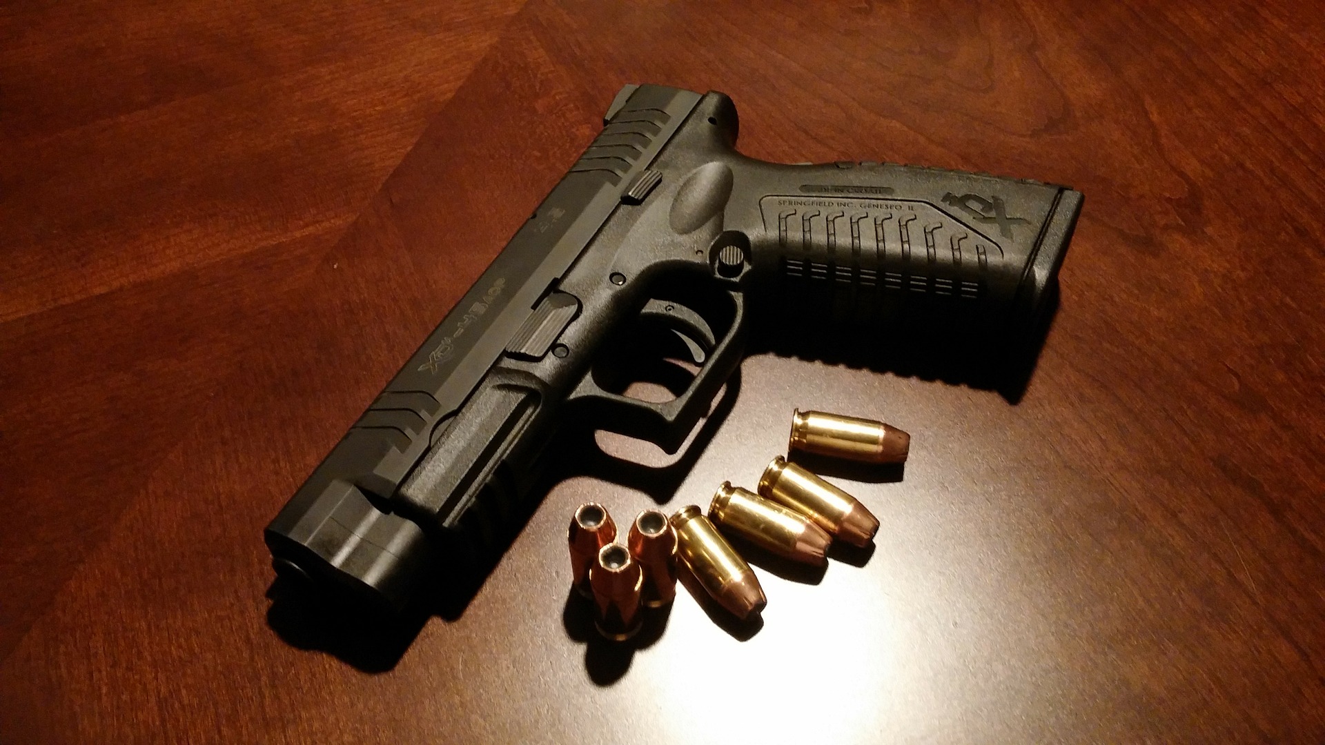 image of a handgun with several bullets