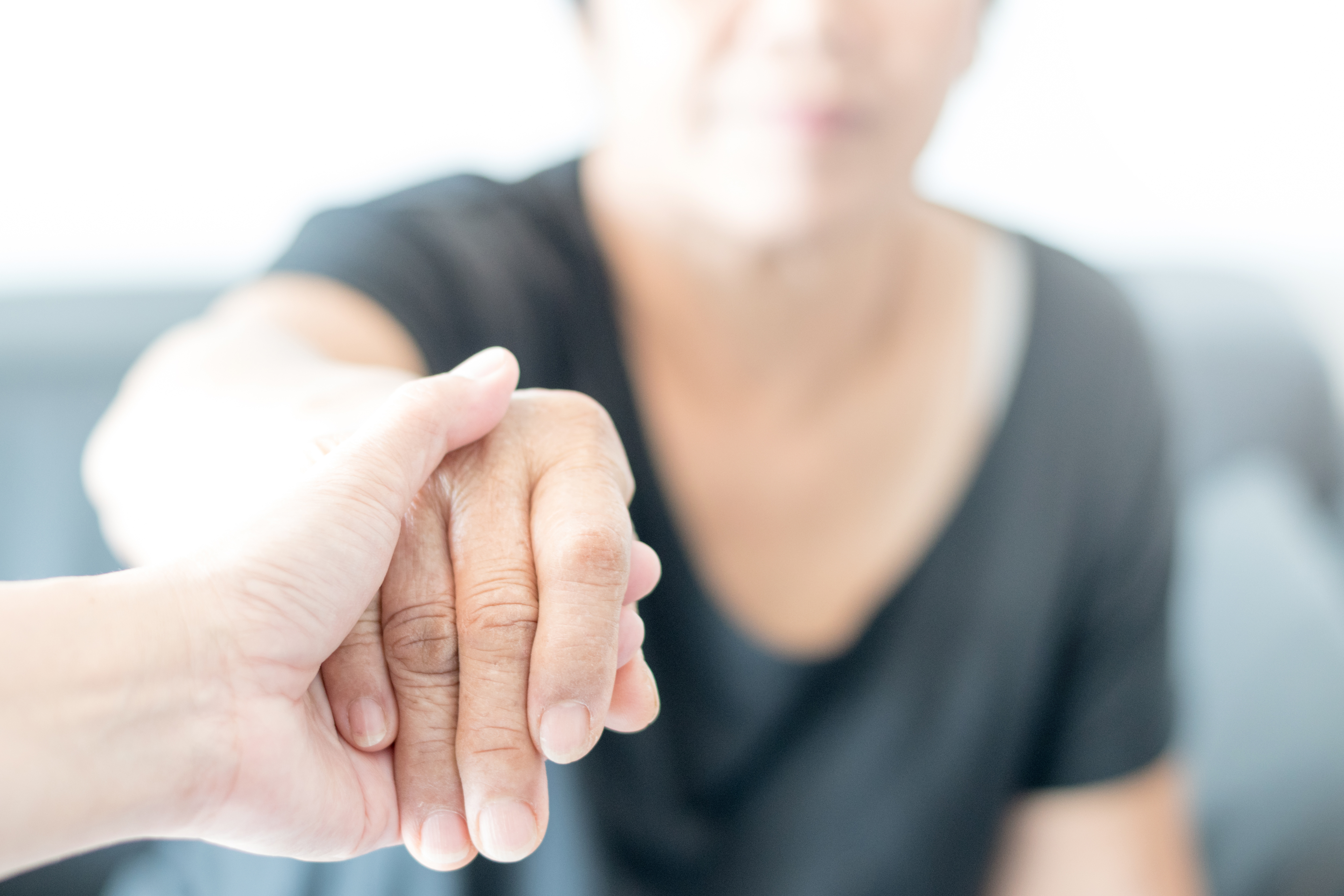 image of a hand holding an senior's hand