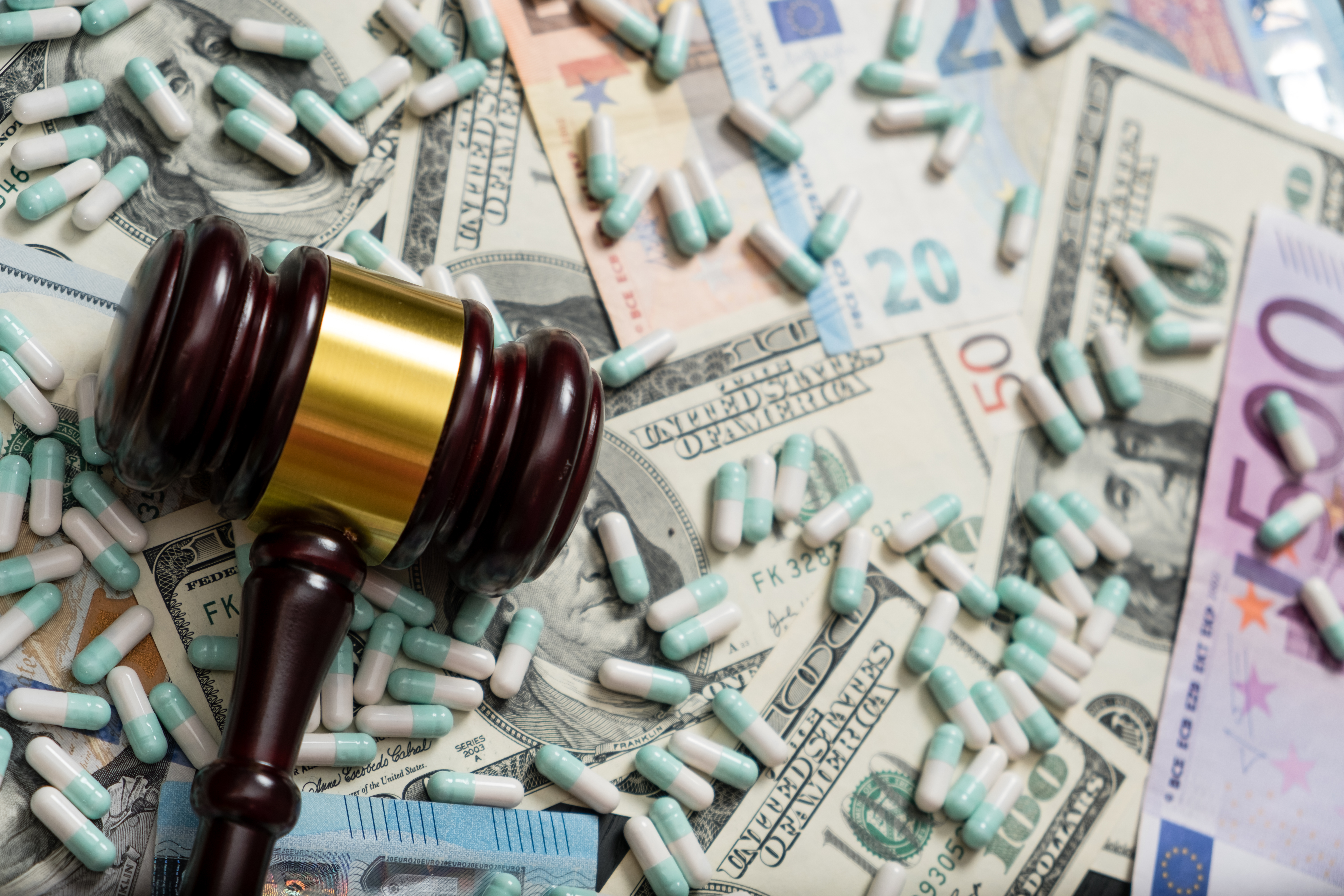 gavel on top of a pile of bills and pills