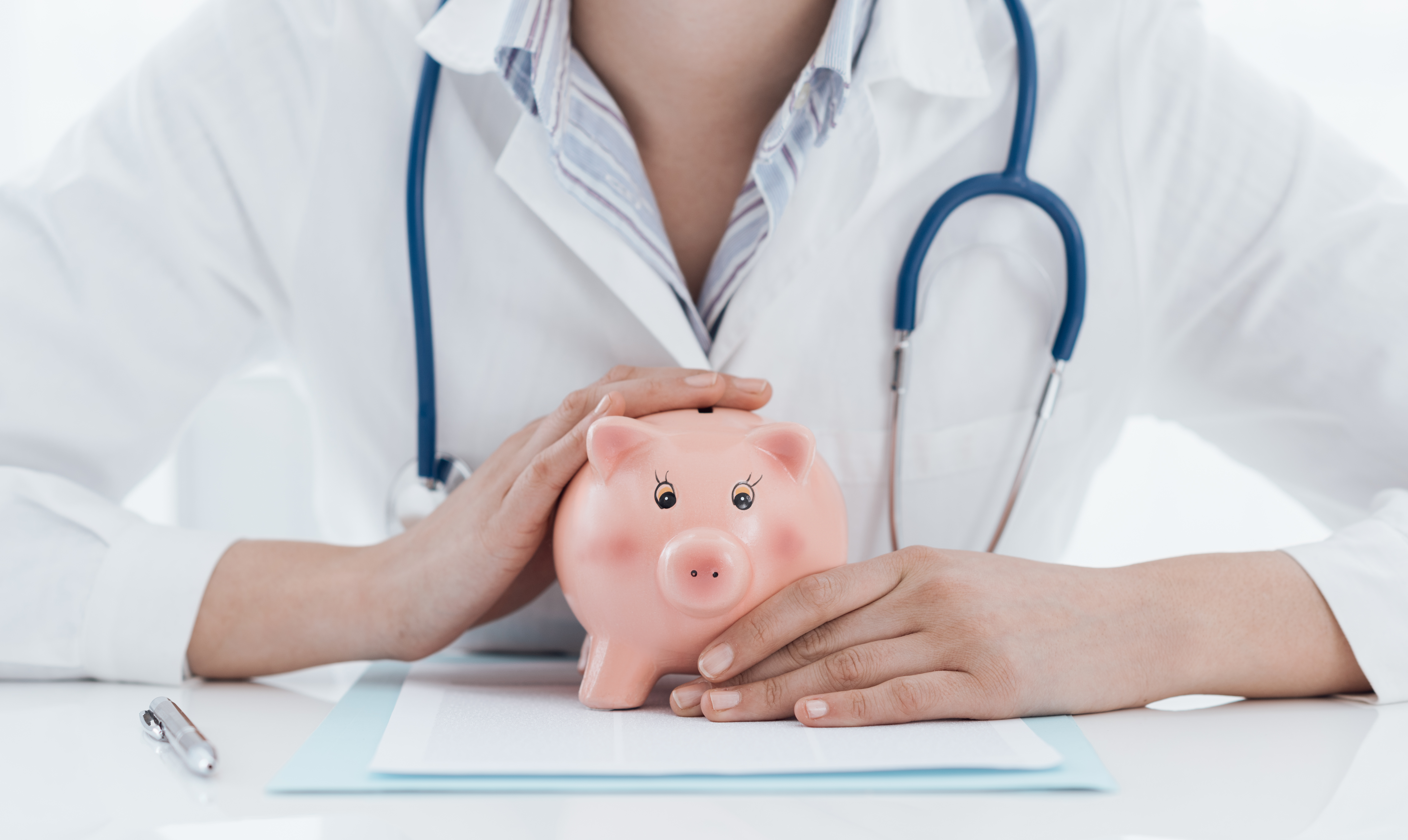 image of a doctor neck-down holding a piggy-bank