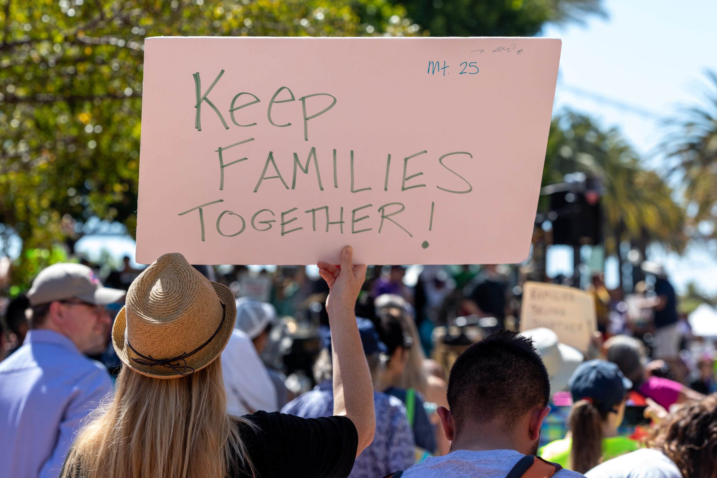 Protestor holding up a sign that reads "Keep families together!"