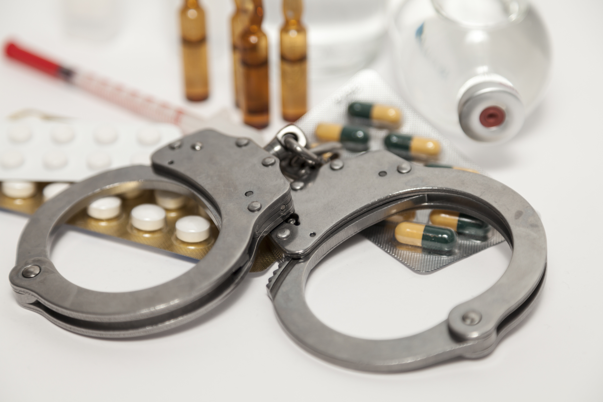 Handcuffs on a pile of pills