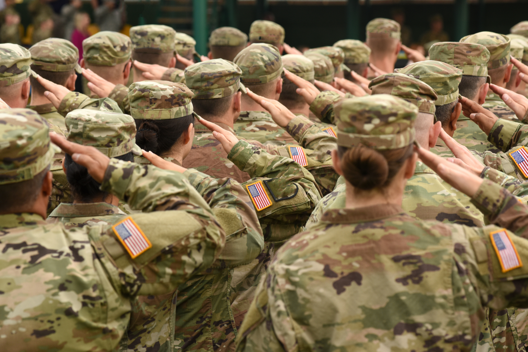 US servicemembers pictured from behind, saluting