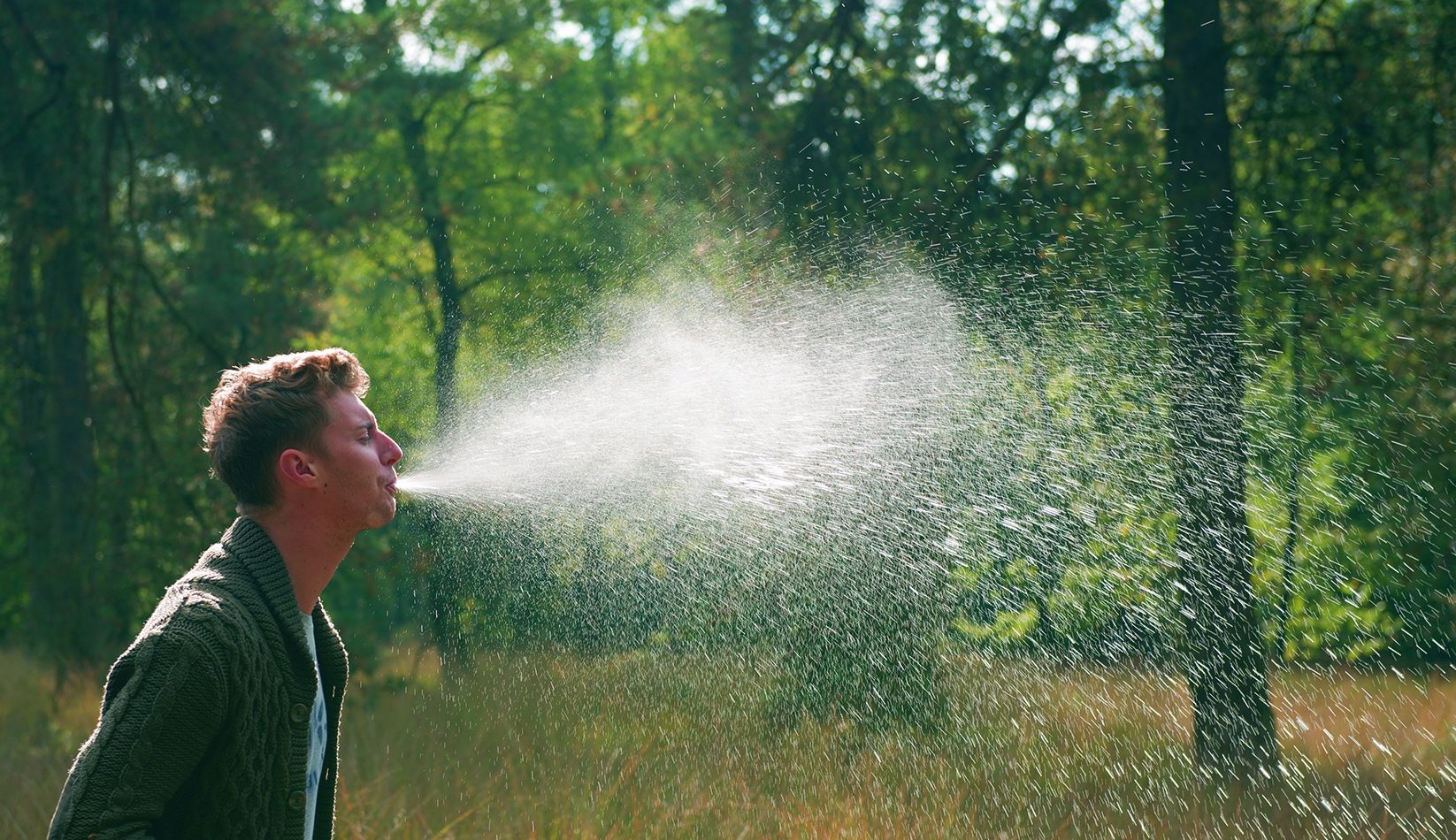 Image of a man spurting out water from his mouth