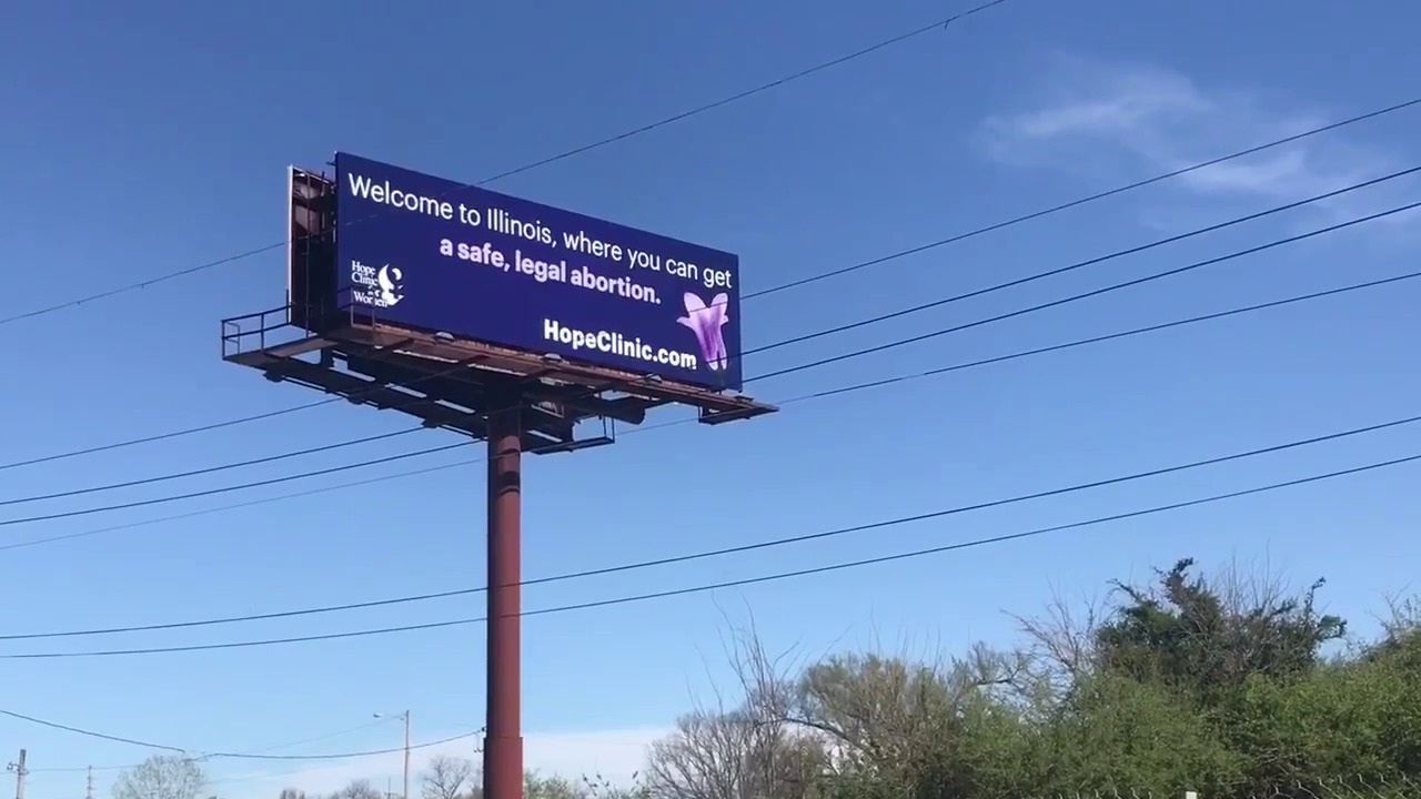 A billboard that reads "Welcome to Illinois, where you can get a safe, legal abortion."