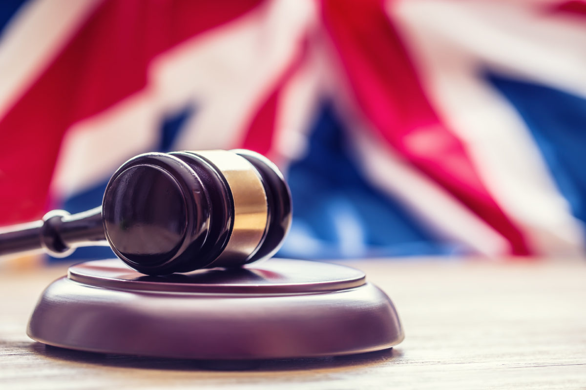 Photograph of a gavel in front of a British flag