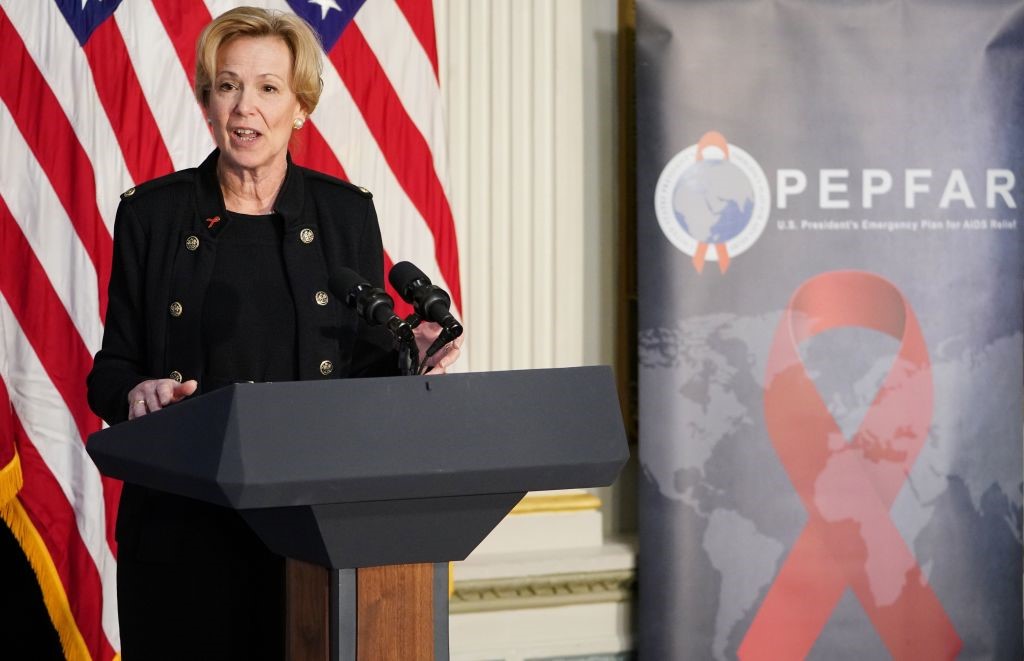 Ambassador-at-Large Deborah Birx giving a speech from a podium with an American flag and PEPFAR banner in the background