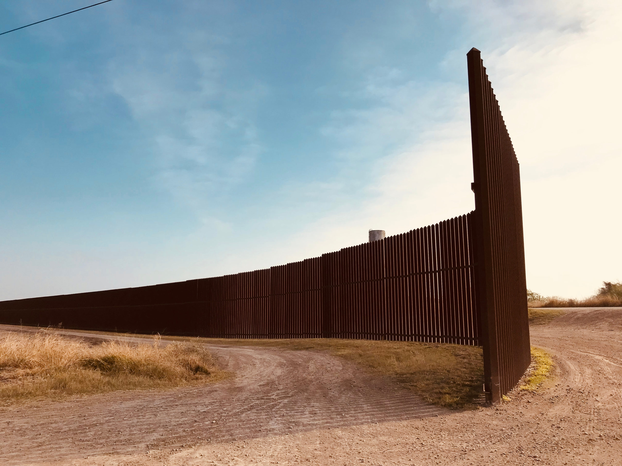 U.S.-Mexico border wall in Texas near a dirt road