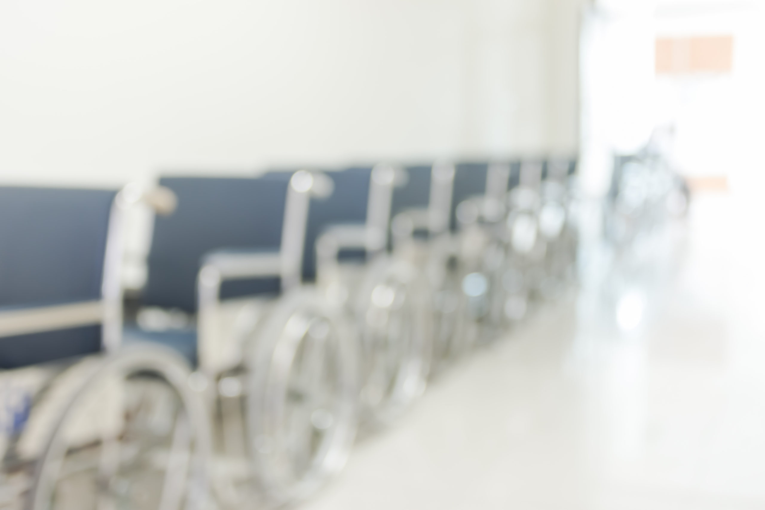 Soft-focus photograph of wheelchairs lined up in a hospital hallway