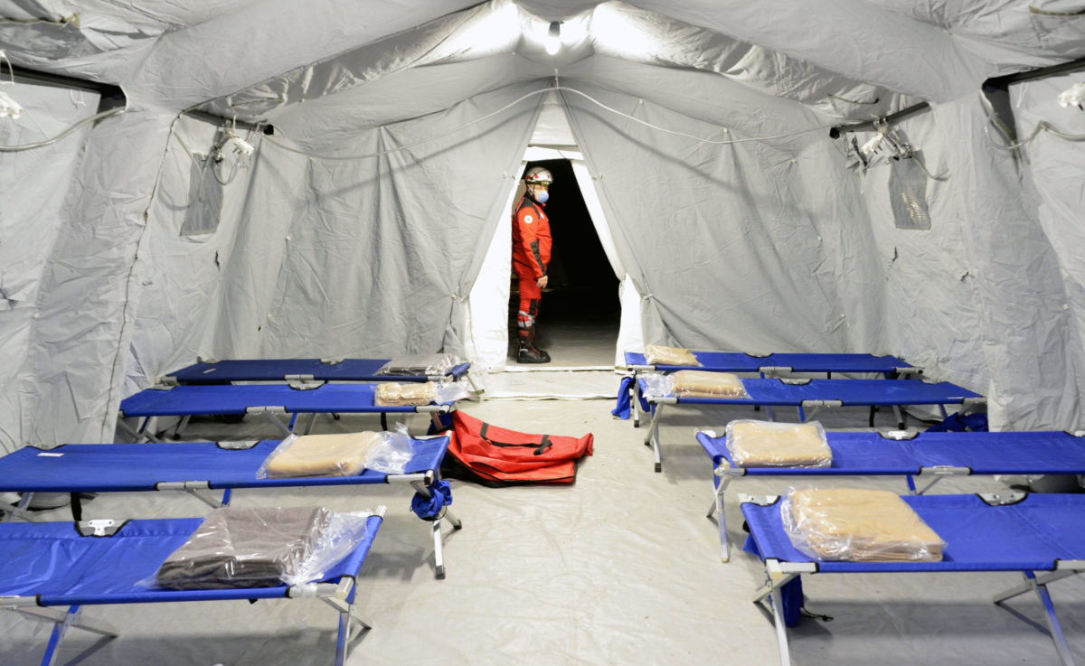 LOMBARDIA, ITALY - FEBRUARY 26, 2020: Empty hospital field tent for the first AID, a mobile medical unit of red cross for patient with Corona Virus. Camp room for people infected with an epidemic.