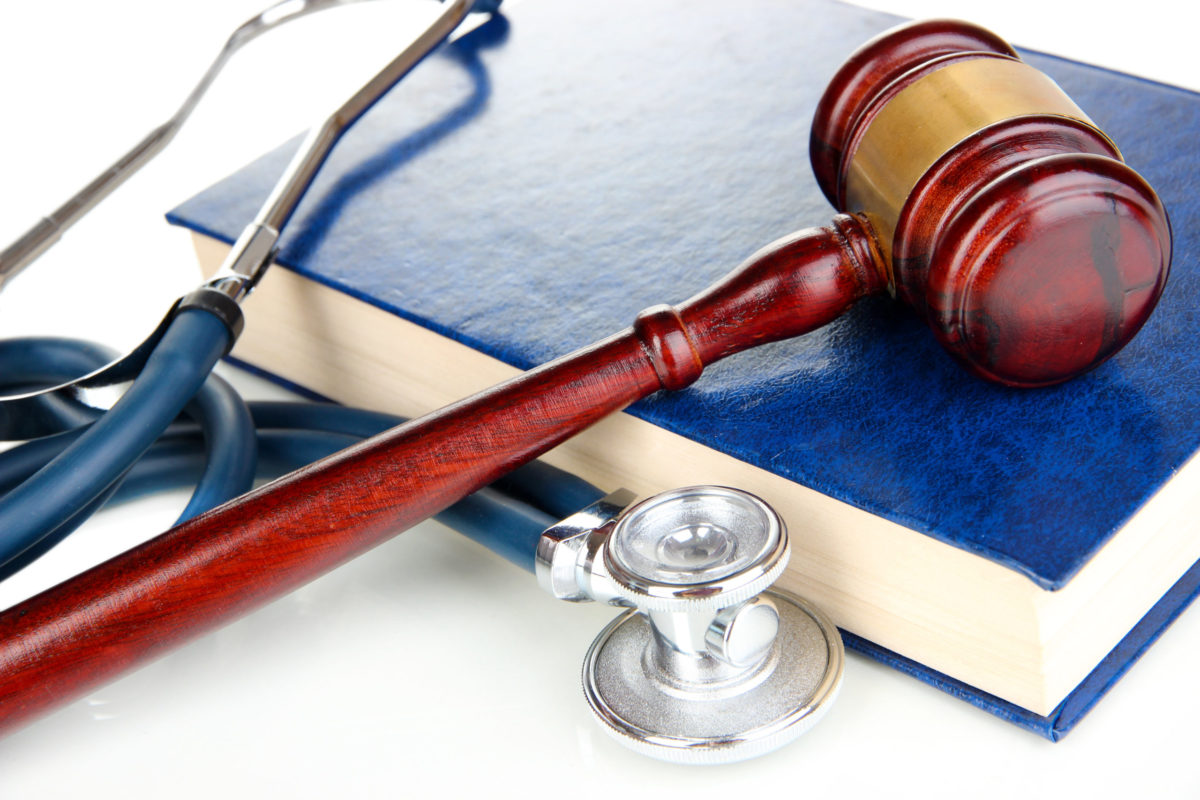 Medicine law concept. Gavel and stethoscope on book close up