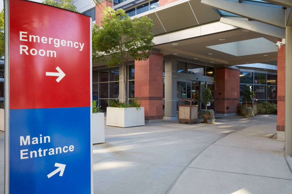 Main Entrance Of Modern Hospital Building With Signs.