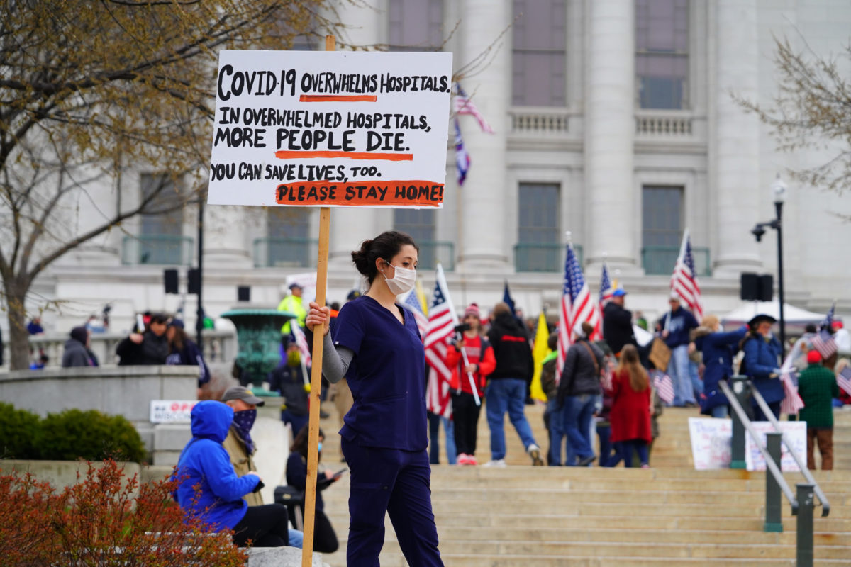 Madison, Wisconsin / USA - April 24th, 2020: Nurses at Reopen Wisconsin Protesting against the protesters protesting safer at home order rally holding signs telling people to go home.