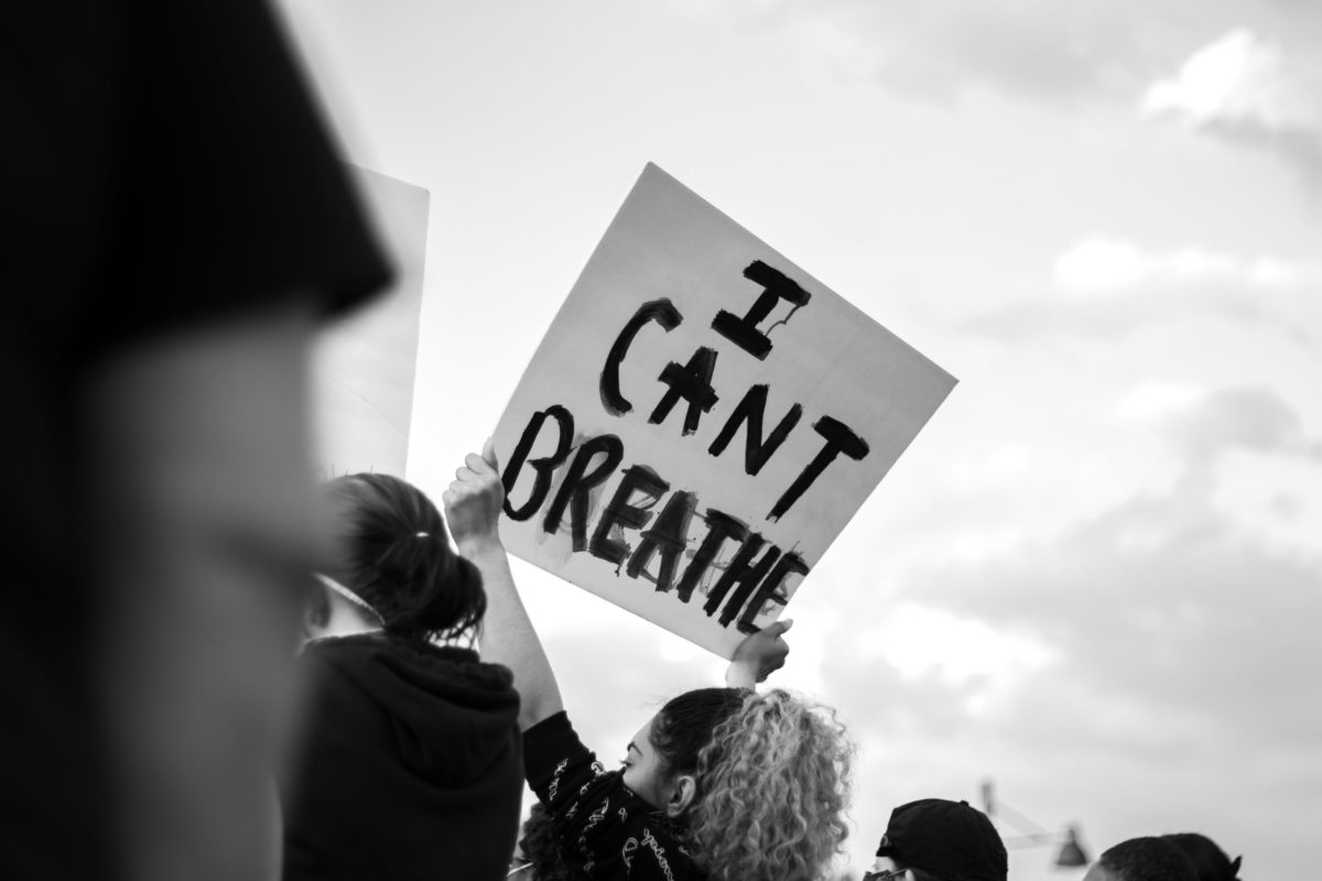 Woman holding sign that reads "I can't breathe."