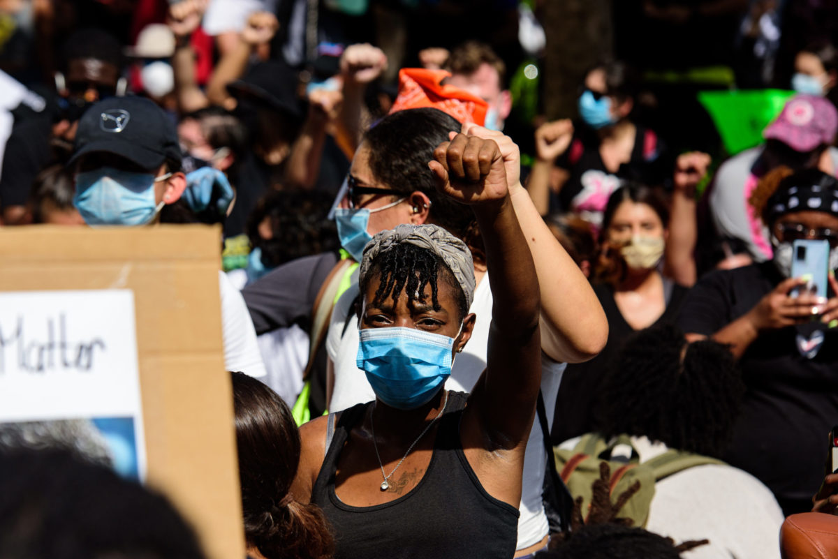 Miami Downtown, FL, USA - MAY 31, 2020: Woman leading a group of demonstrators on road protesting for human rights and against racism.