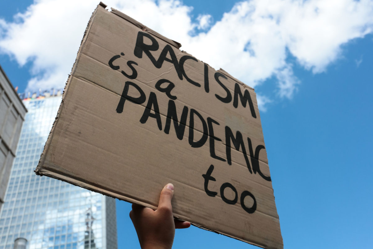 Sign that reads "Racism is a pandemic too."