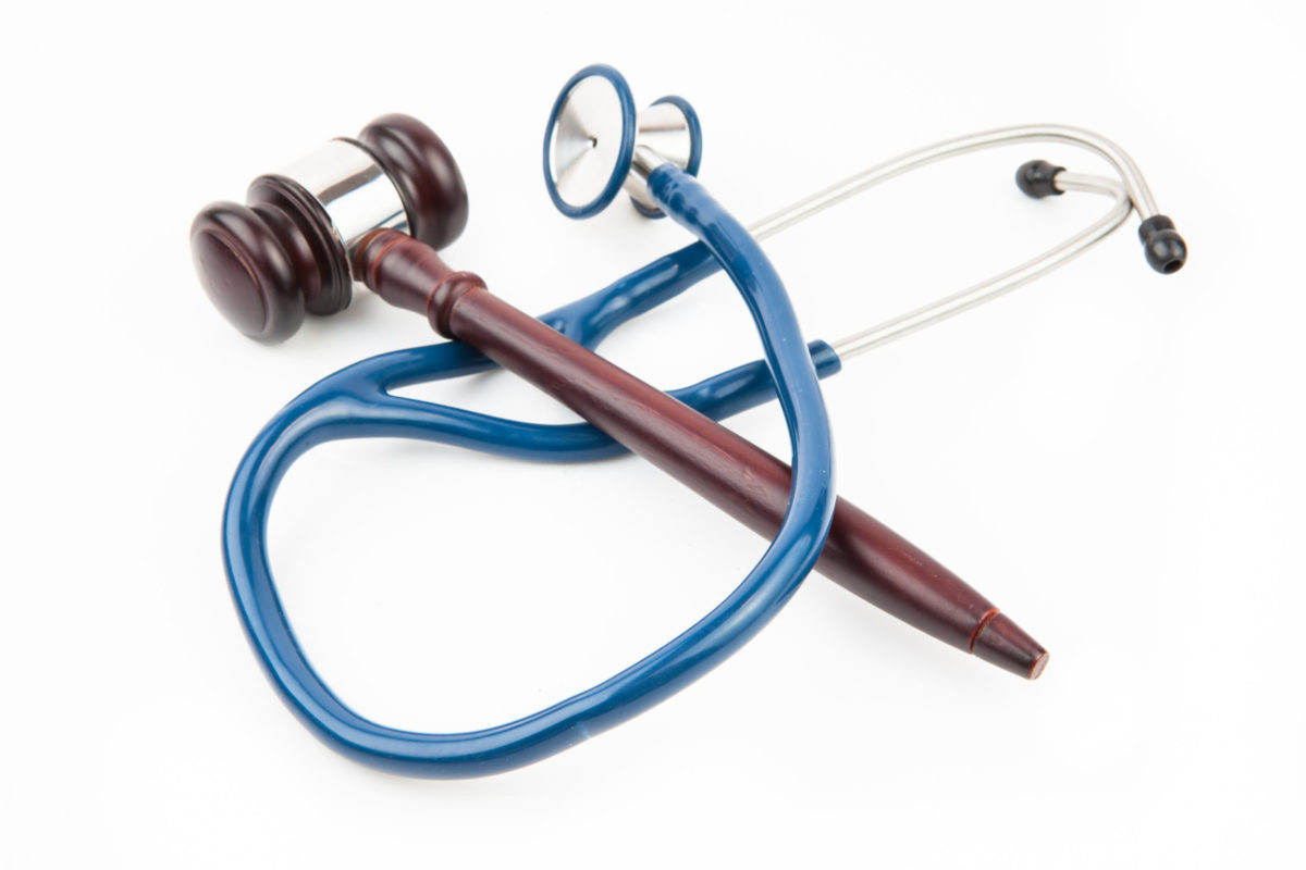 Blue stethoscope with gavel on white background