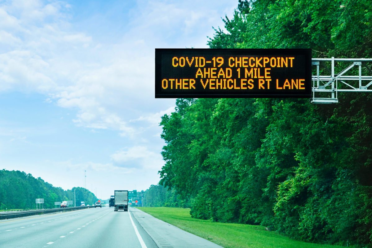 Highway alert: Covid-19 checkpoint ahead, overhead sign in Florida on state border.