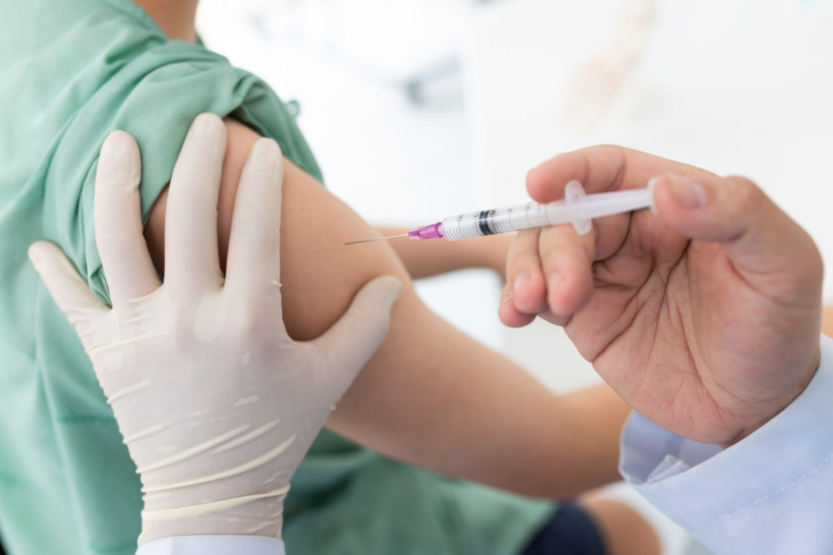 Close up of a Doctor making a vaccination in the shoulder of patient.