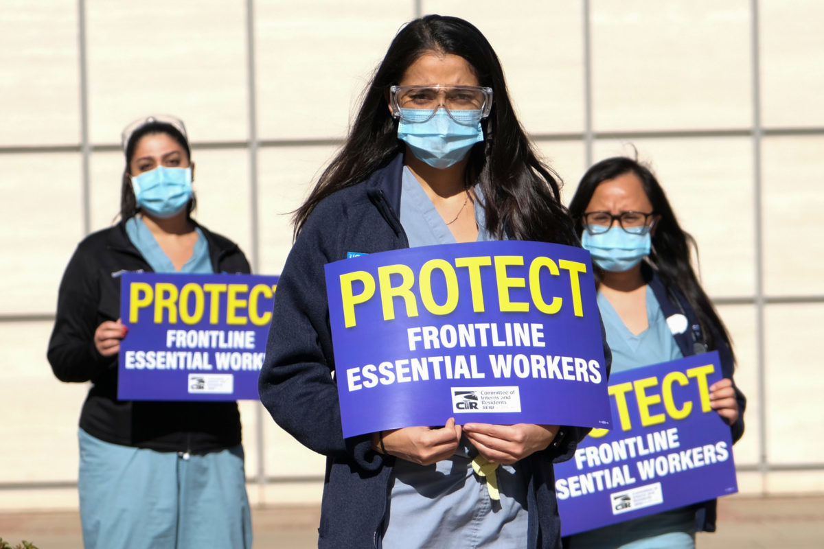 Healthcare workers carrying signs protest for improved Covid-19 testing and workplace safety policies outside of UCLA Medical Center in Los Angeles,Dec. 9, 2020.