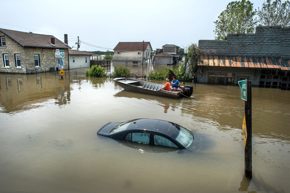 Grafton, Illinois, USA, June 1, 2019 -Car submerged under flood water in small river town, Grafton, Illinois, as Mississippi River floods roads, businesses and houses. vehicle under water, men in boat