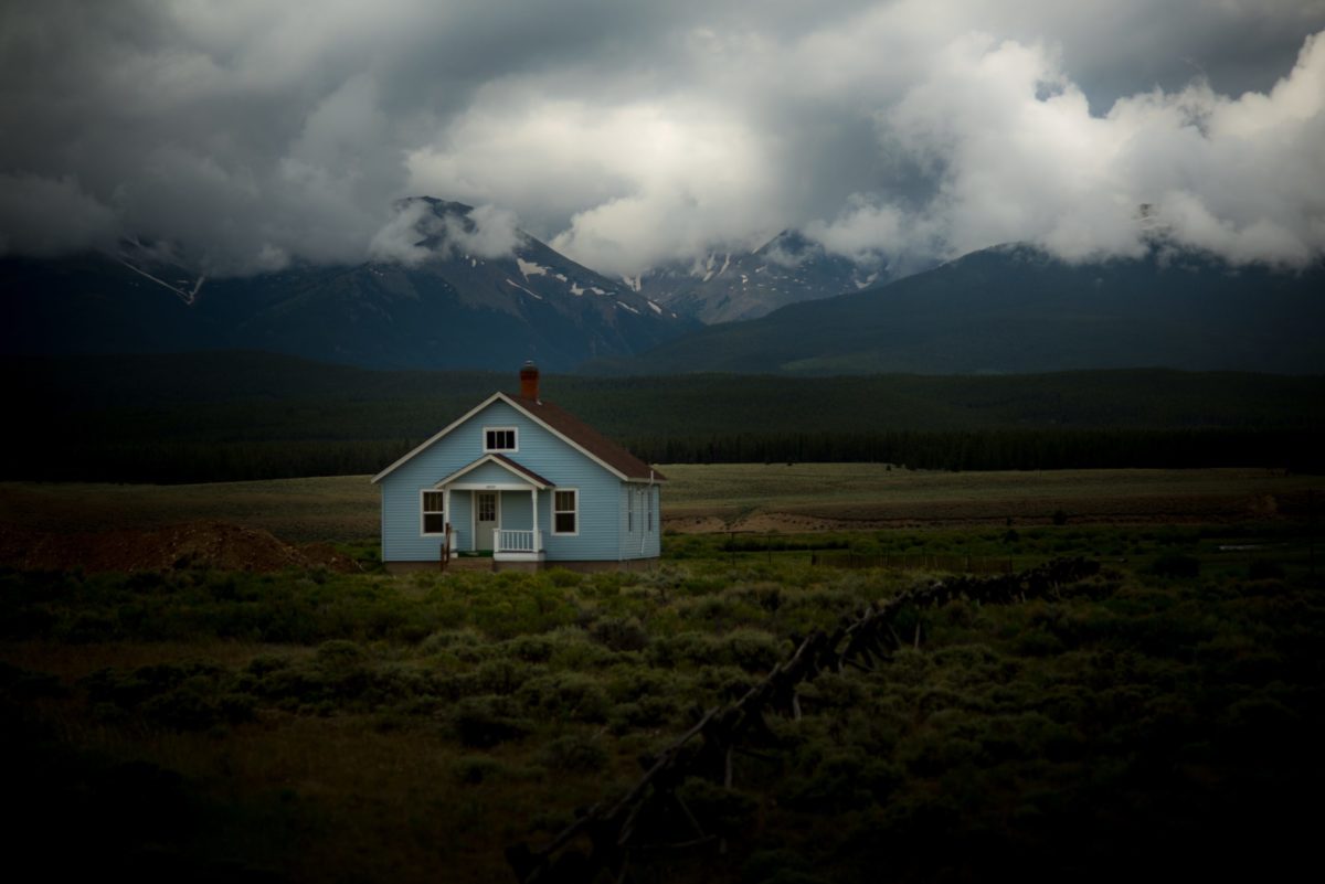 Blue house in grass field.