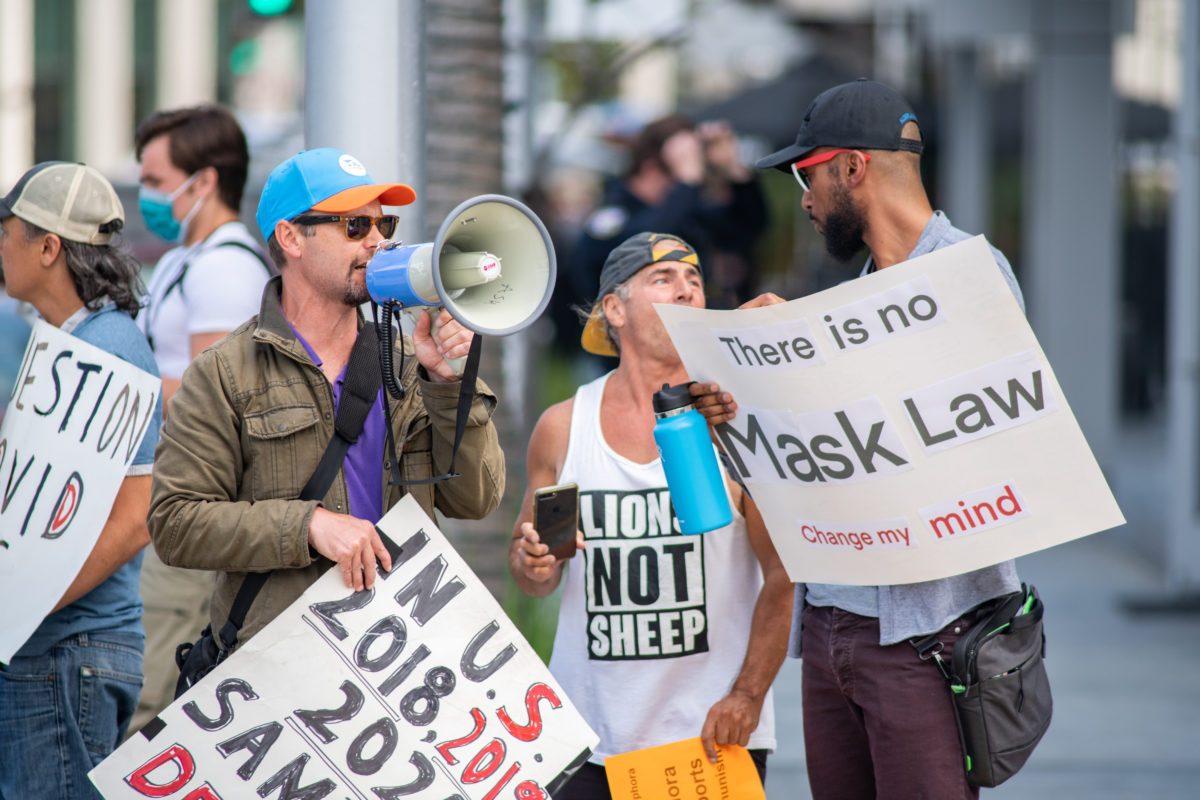 Beverly Hills, CA: April 7, 2021: Anti-mask protesters holding signs related to COVID-19. Beverly Hills and the state of California have a mask mandate requirement.