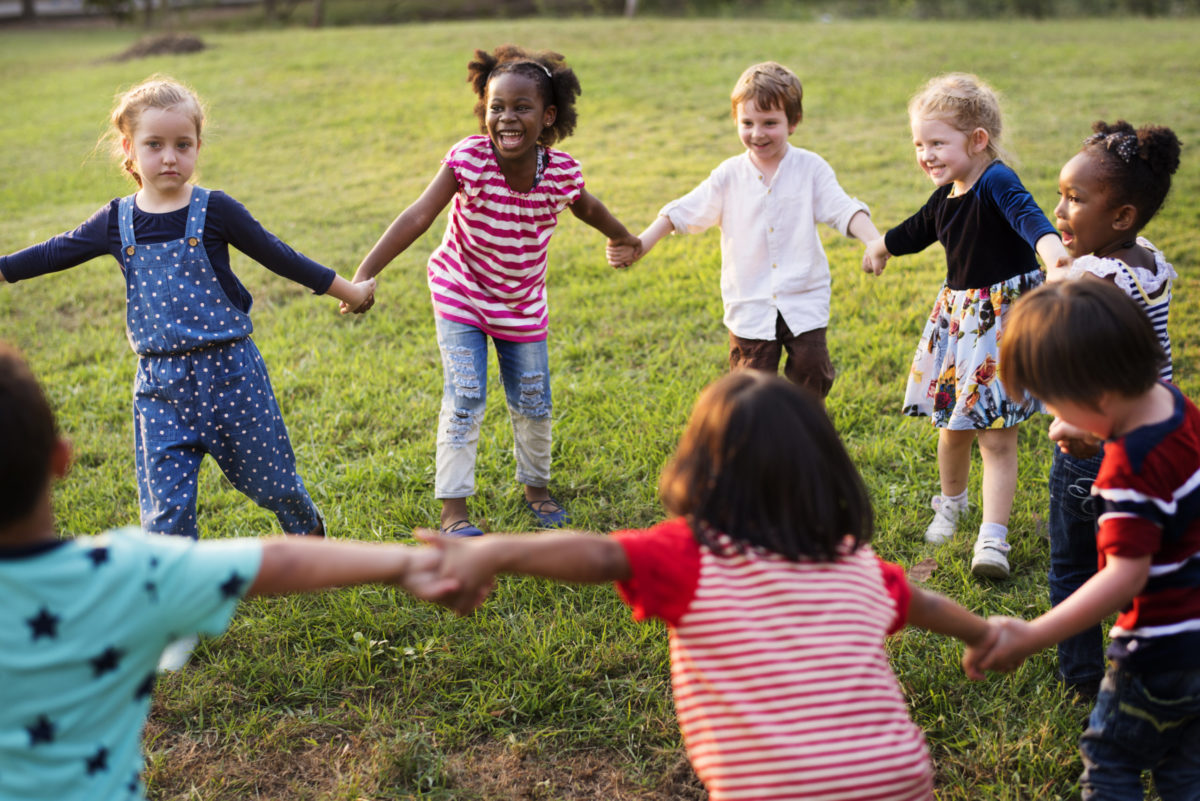 Group of Diverse Kids Playing in a Field Together.