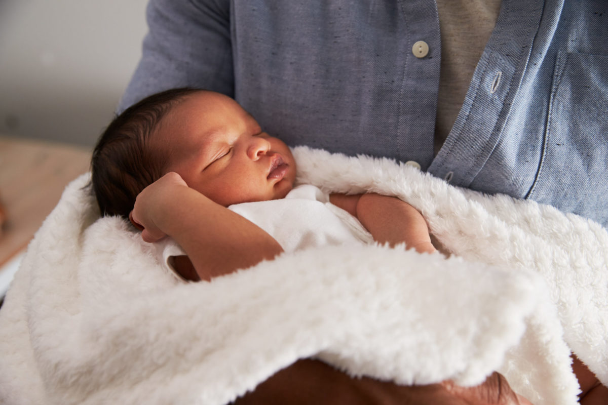 Baby held in someone's arms.