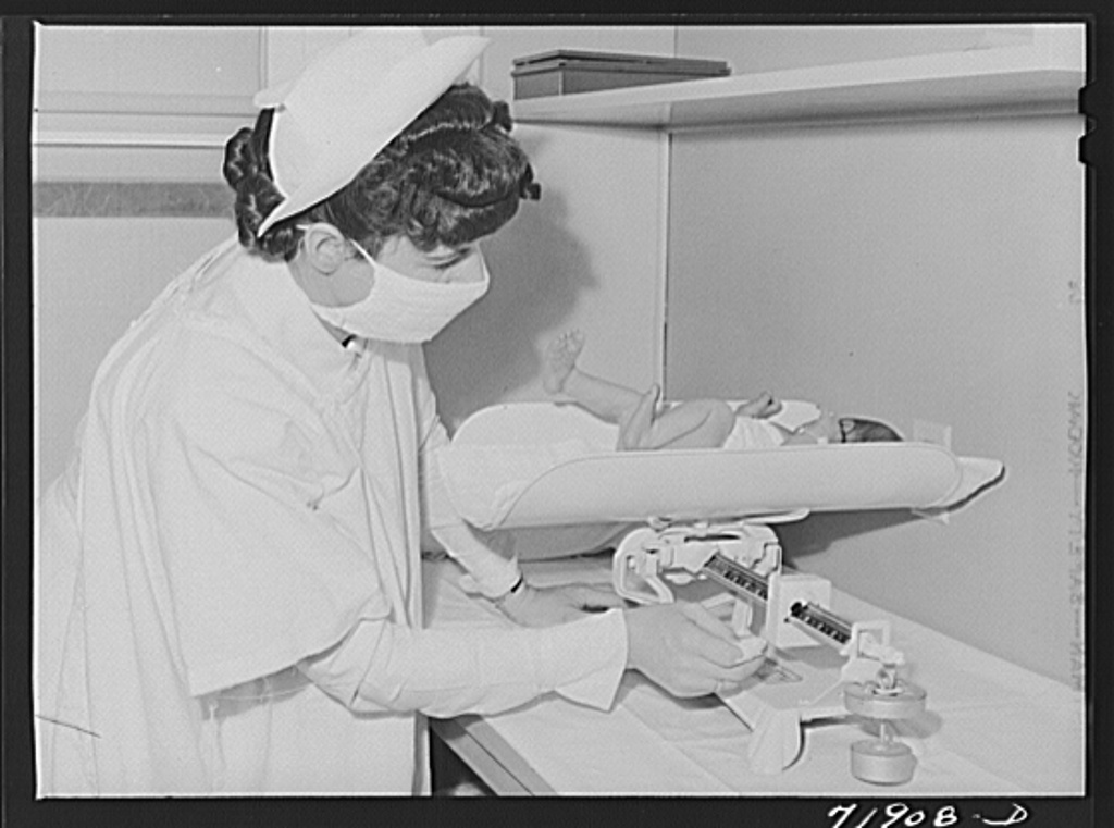 Nurse weighs baby in the nursery of the Cairns General Hospital at the FSA (Farm Security Administration) farm workers' community. Eleven Mile Corner, Arizona.