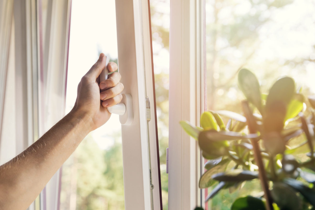 hand opening white plastic pvc window at home.