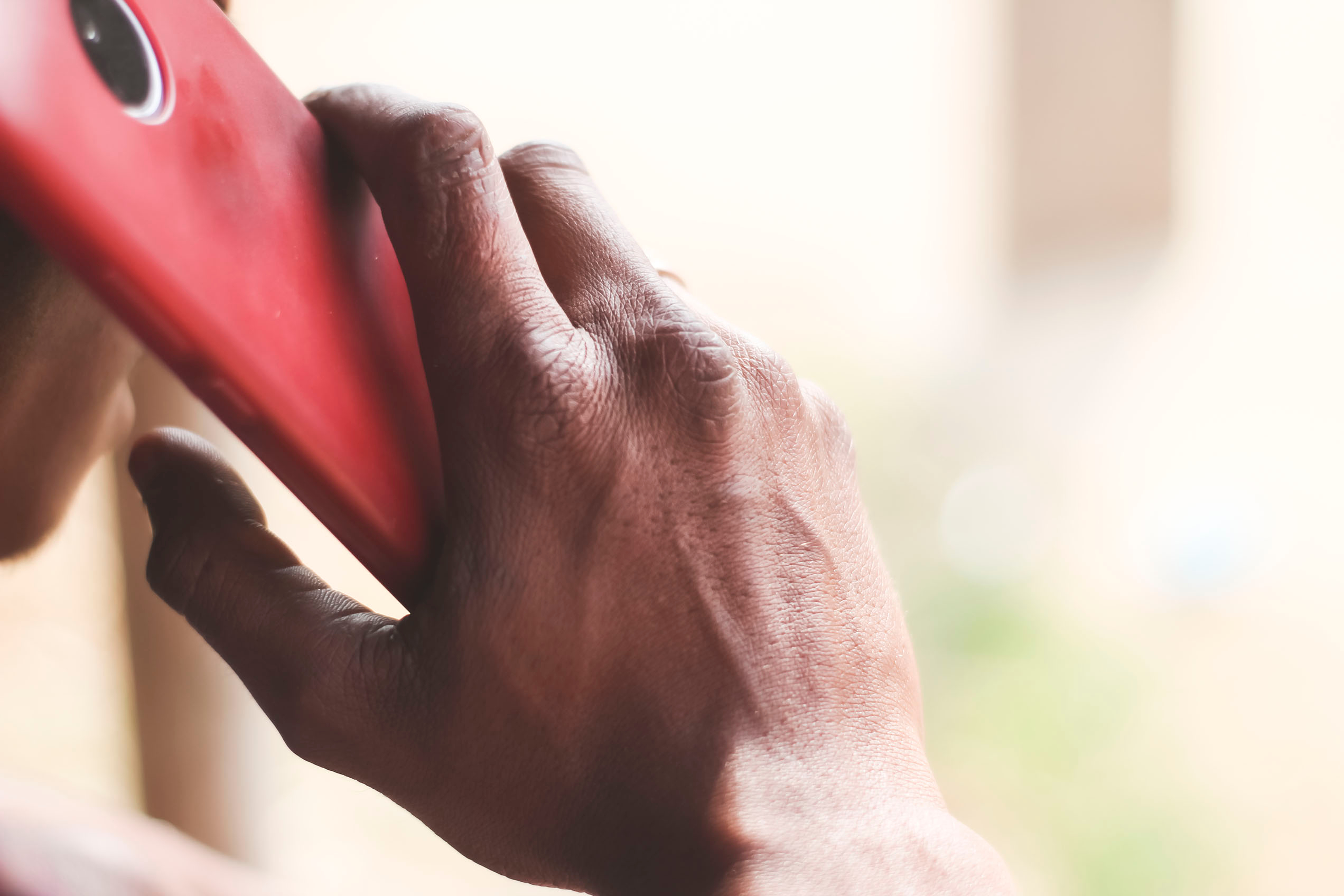 Bill of Health - Women holds red cellphone to her hear, calling domestic violence support, domestic violence support during the pandemic