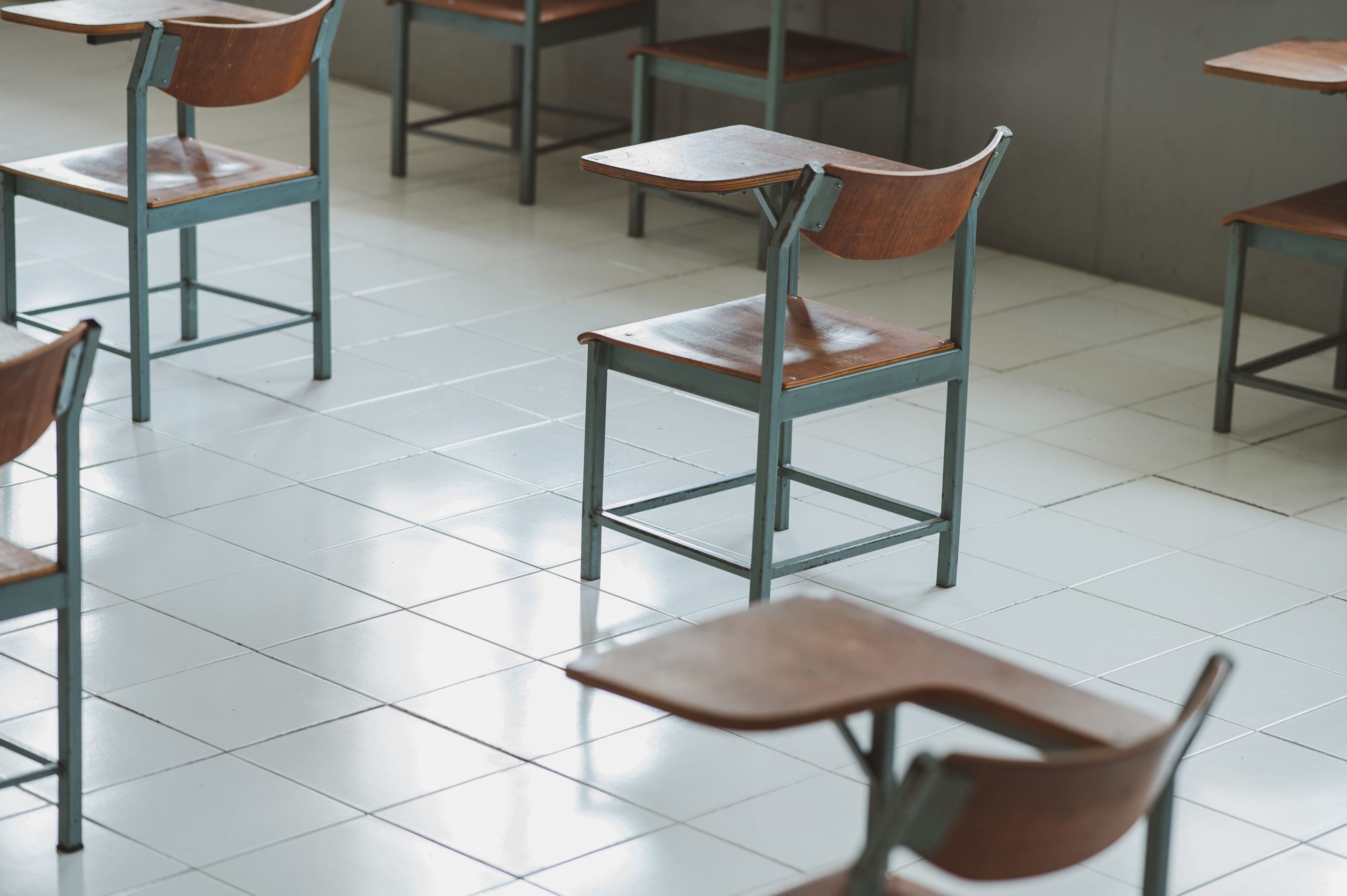 Bill of Health - empty desks in a classroom showing absenteeism during the pandemic, with the desks spaced apart