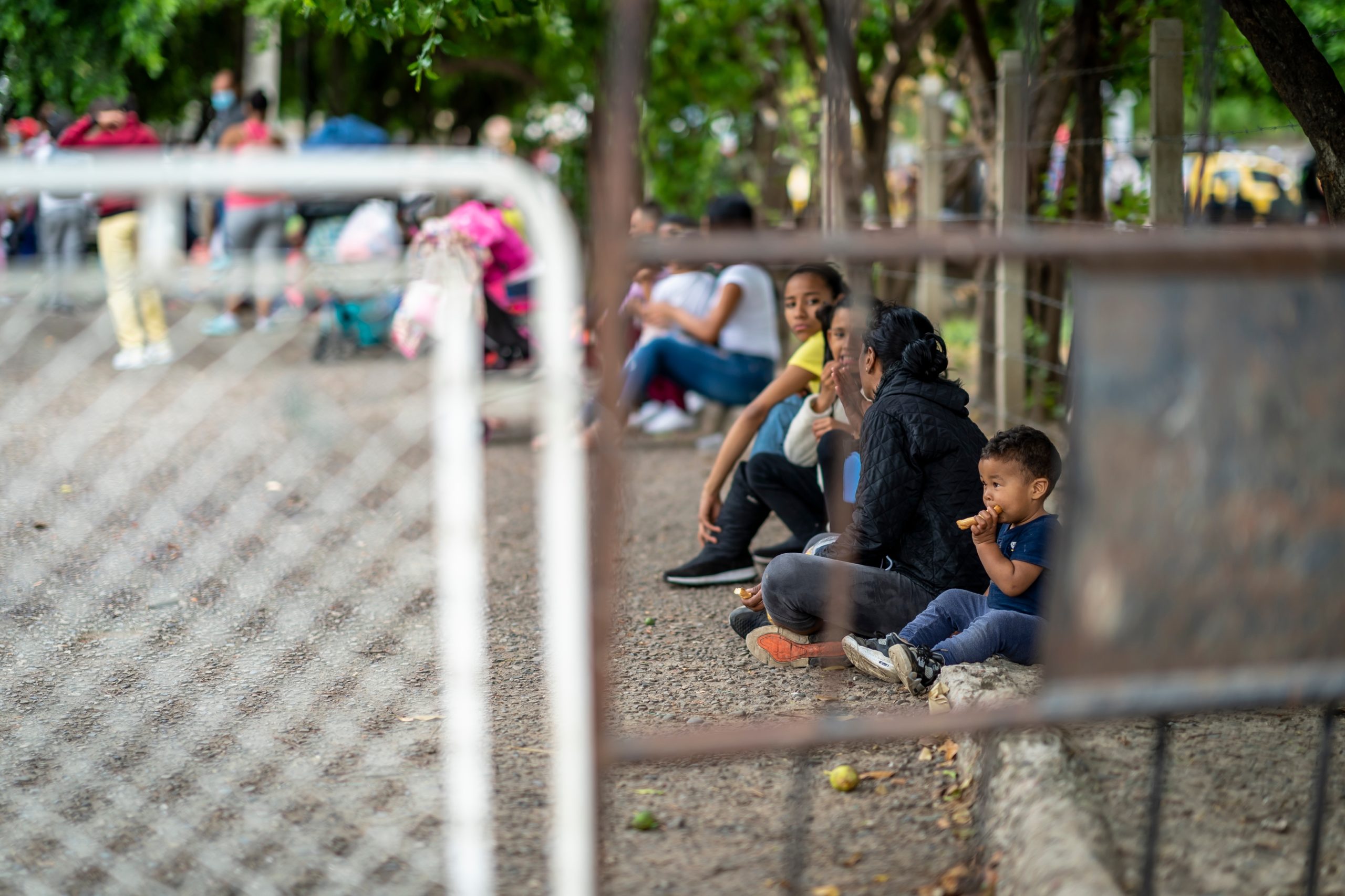 Bill of Health - Venezuelan migrant family behind a fence in Colombia, covid-19 migrant crisis