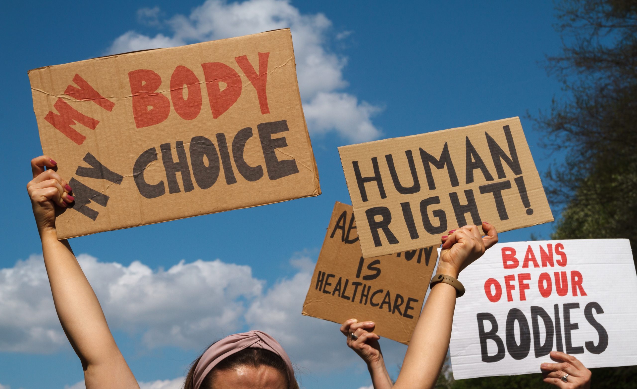 Protesters holding signs that read My Body My Choice, Human right, Bans Off Our Bodies, Abortion Is Healthcare.