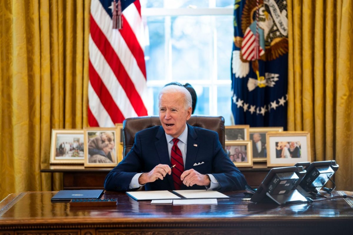 President Joe Biden at desk in Oval Office.