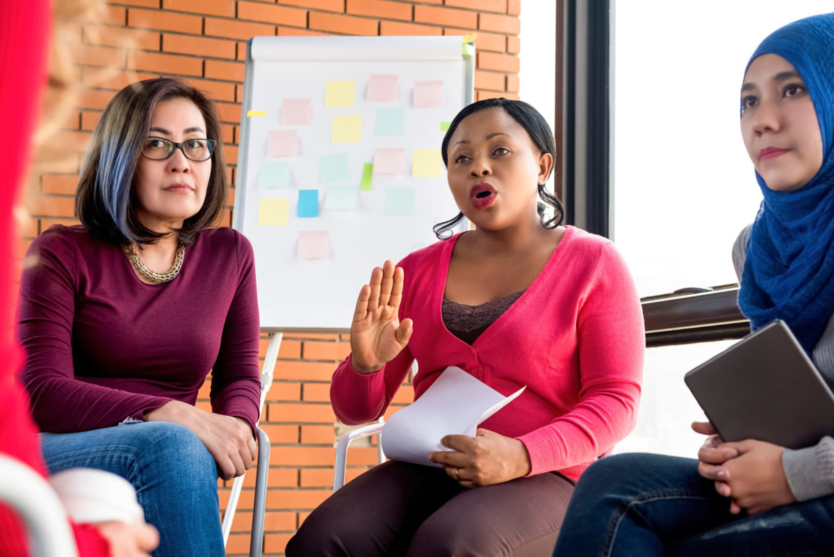 Multiethnic women in colorful casual clothes discussing in the group meeting.