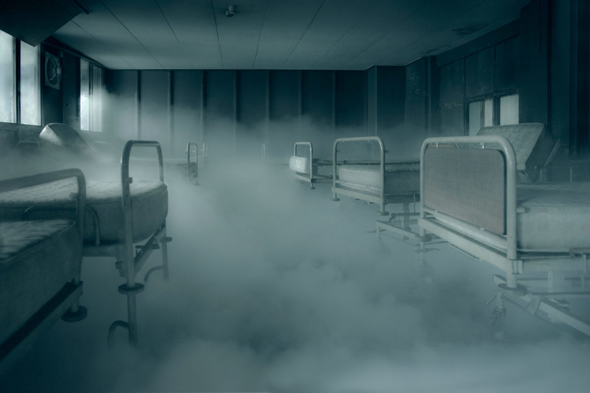 Hospital beds in a room filled with smoke.