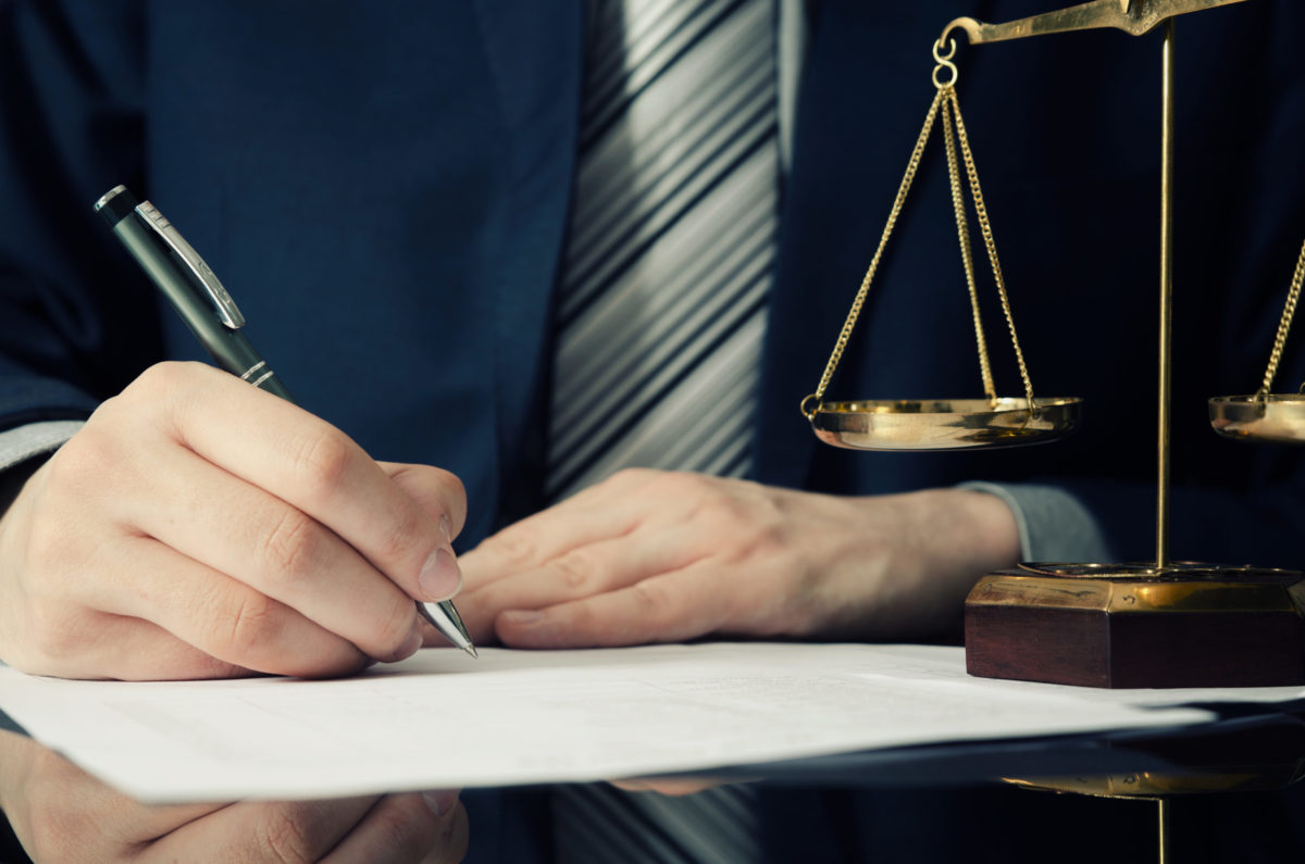 Lawyer working with agreement in office. man signing hand writing pen attorney concept.