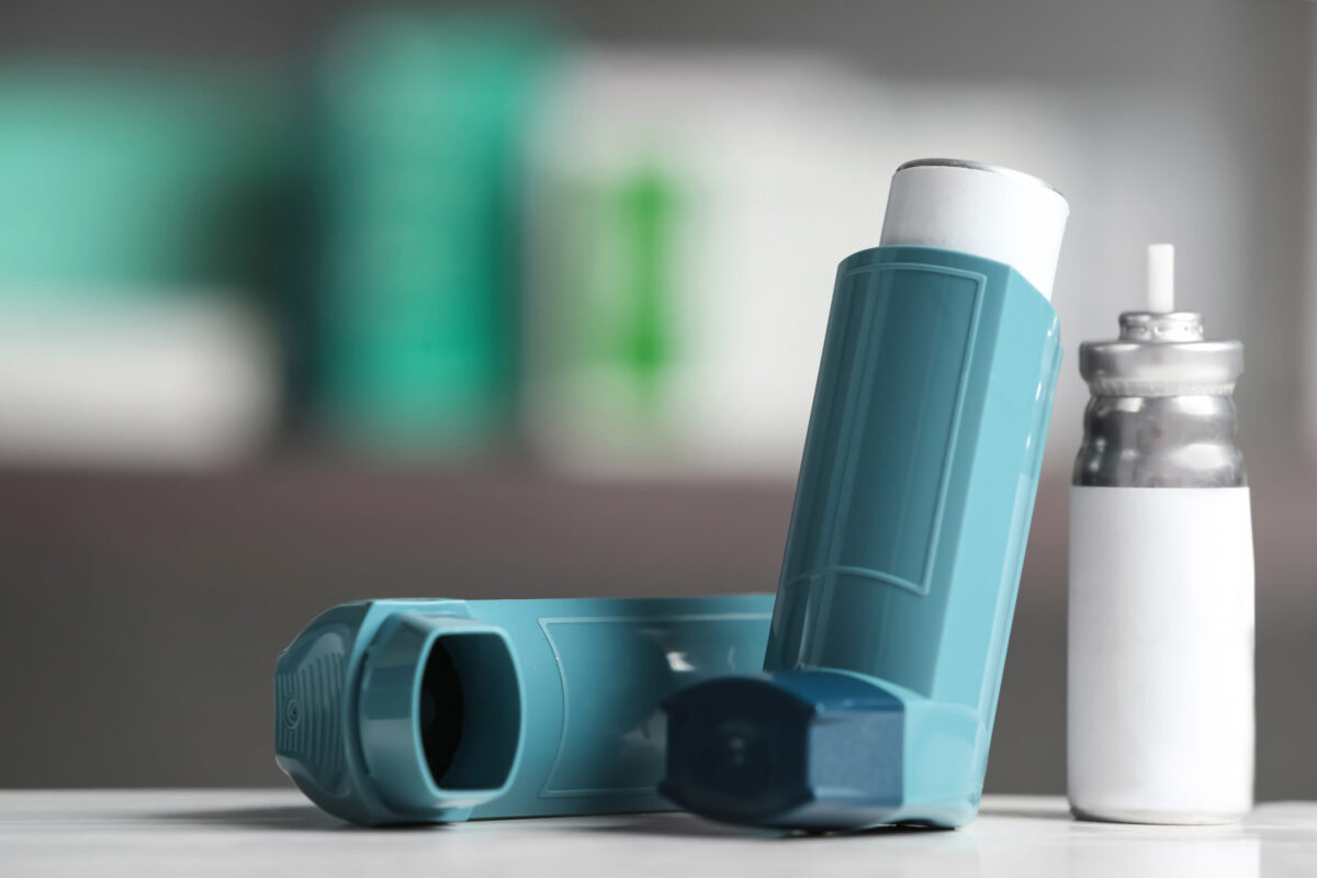 Asthma inhalers on table against blurred background.