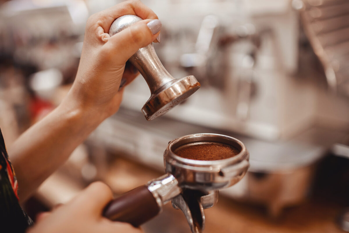 Close-up - barista prepares espresso in coffee shop.