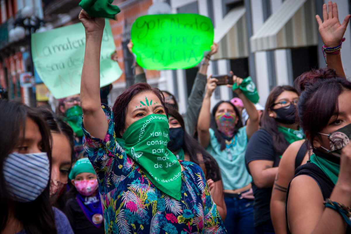 Puebla, Mexico - September 28, 2020: With green scarves, members of feminist collectives demonstrate in the streets of the Historic Center of Puebla to demand the legalization of abortion.