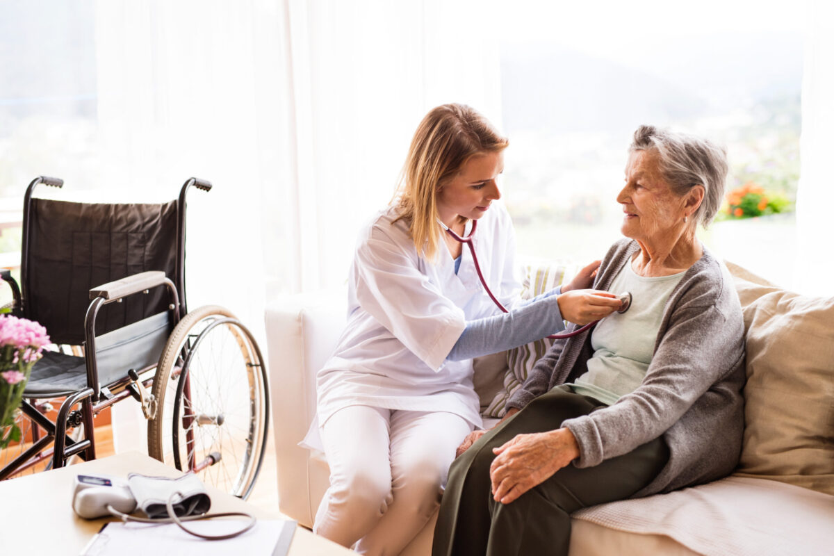 Health visitor and a senior woman during home visit.