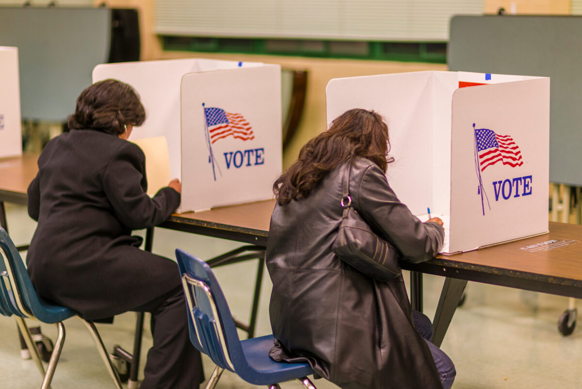 FAIRFAX COUNTY, VIRGINIA, USA - NOVEMBER 4, 2008: Women voters at polls during presidential election, paper ballots.