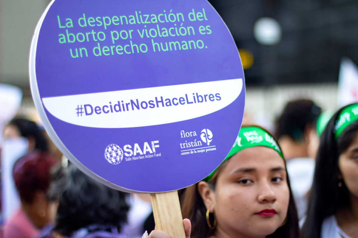 Lima, Peru - March 8 2019: Peruvian girl holding purple banner of abortion rights at Woman's Day March in Lima..