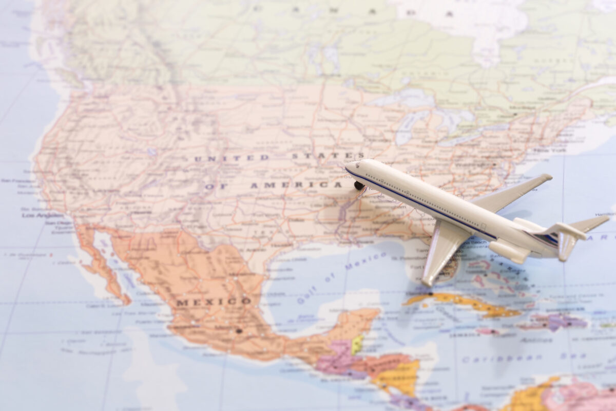 Miniature of a passenger plane flying on the map of United States of America from south east. Conceptual image for tourism and travel.