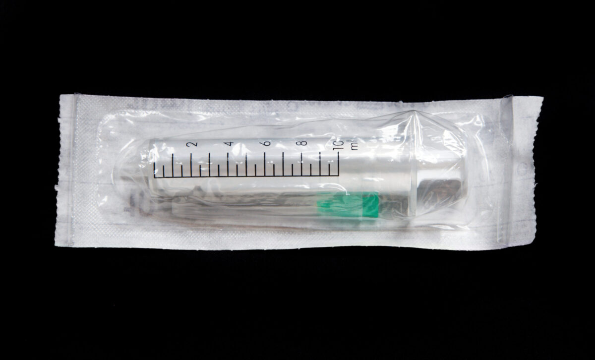 Disposable syringe isolated on black background.